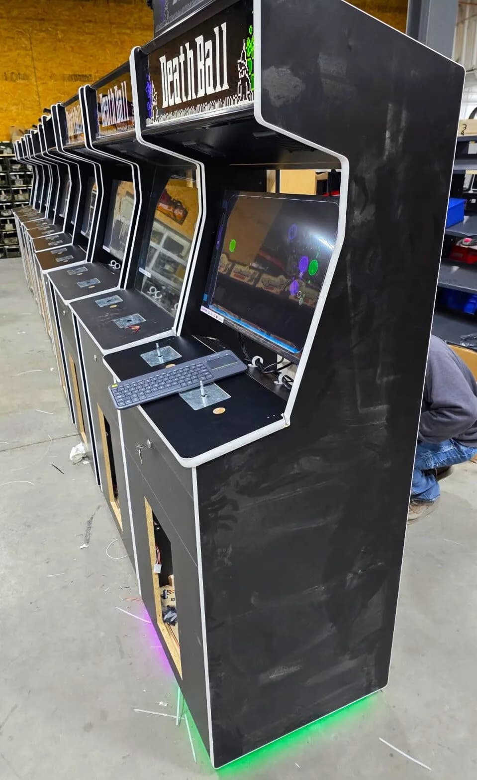 A row of DeathBall cabinets on the Fun Company factory floor